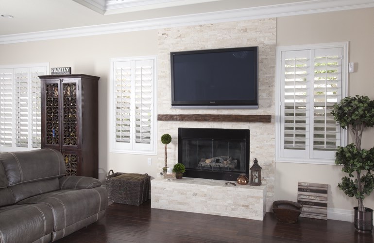 White plantation shutters in a Virginia Beach living room with solid hardwood floors.